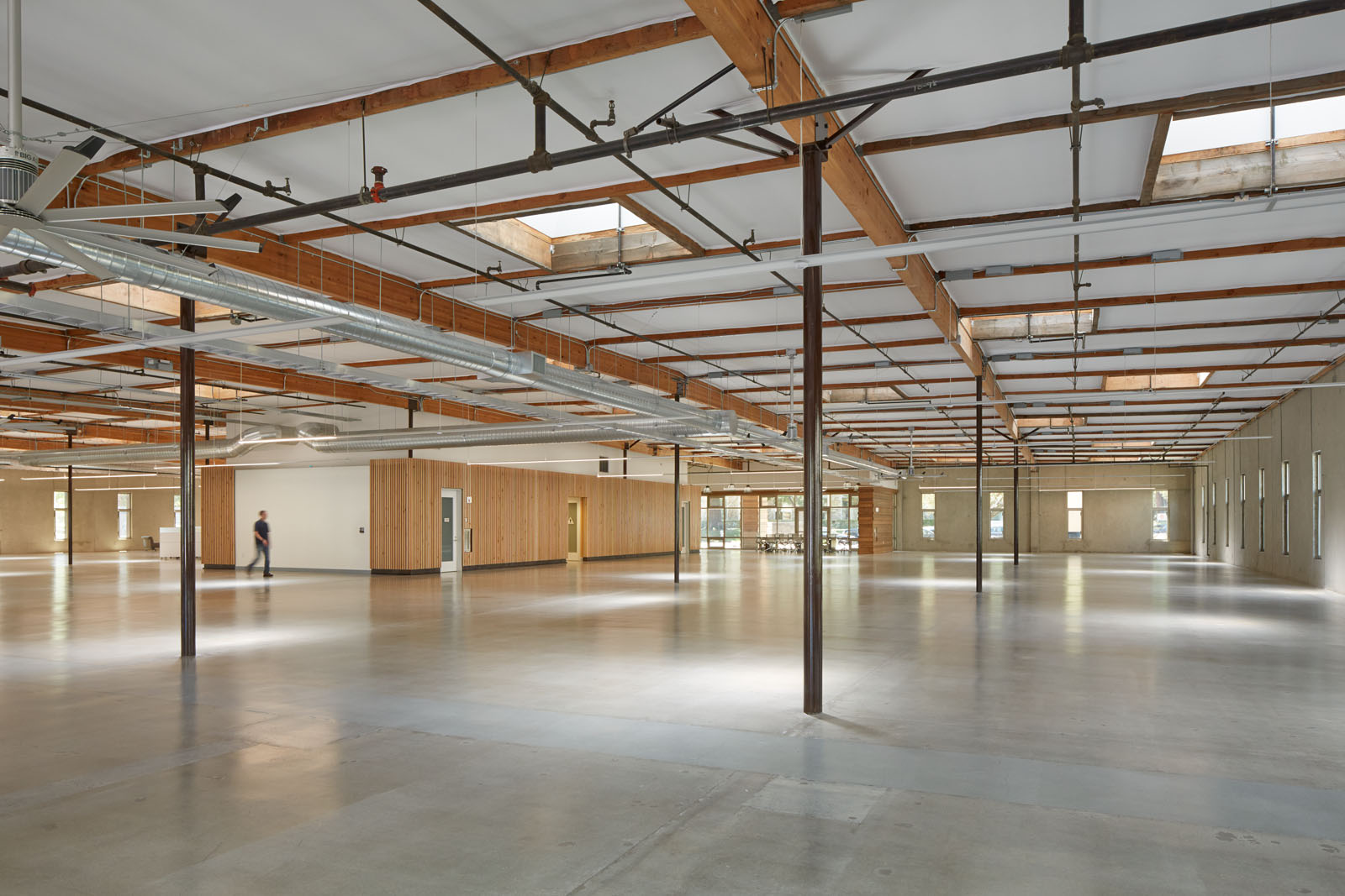 Inside 435 Indio. Concrete slab, wood structure, skylights, and the fan.